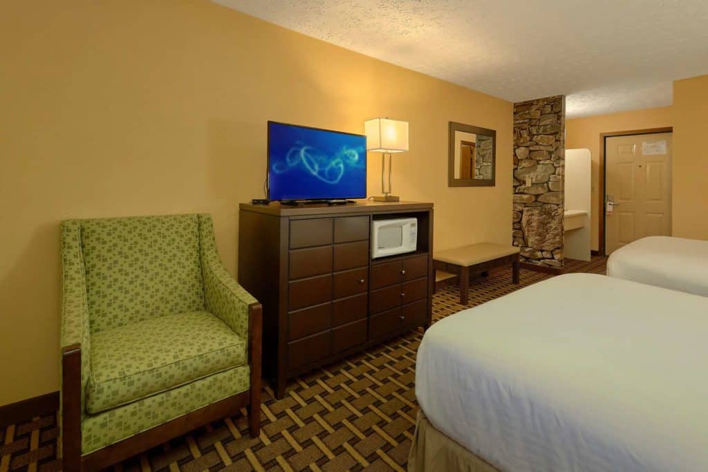 Two Queens with Balcony Room hotel room with tv stand and chair