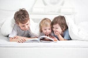 hree little boys reading in bed
